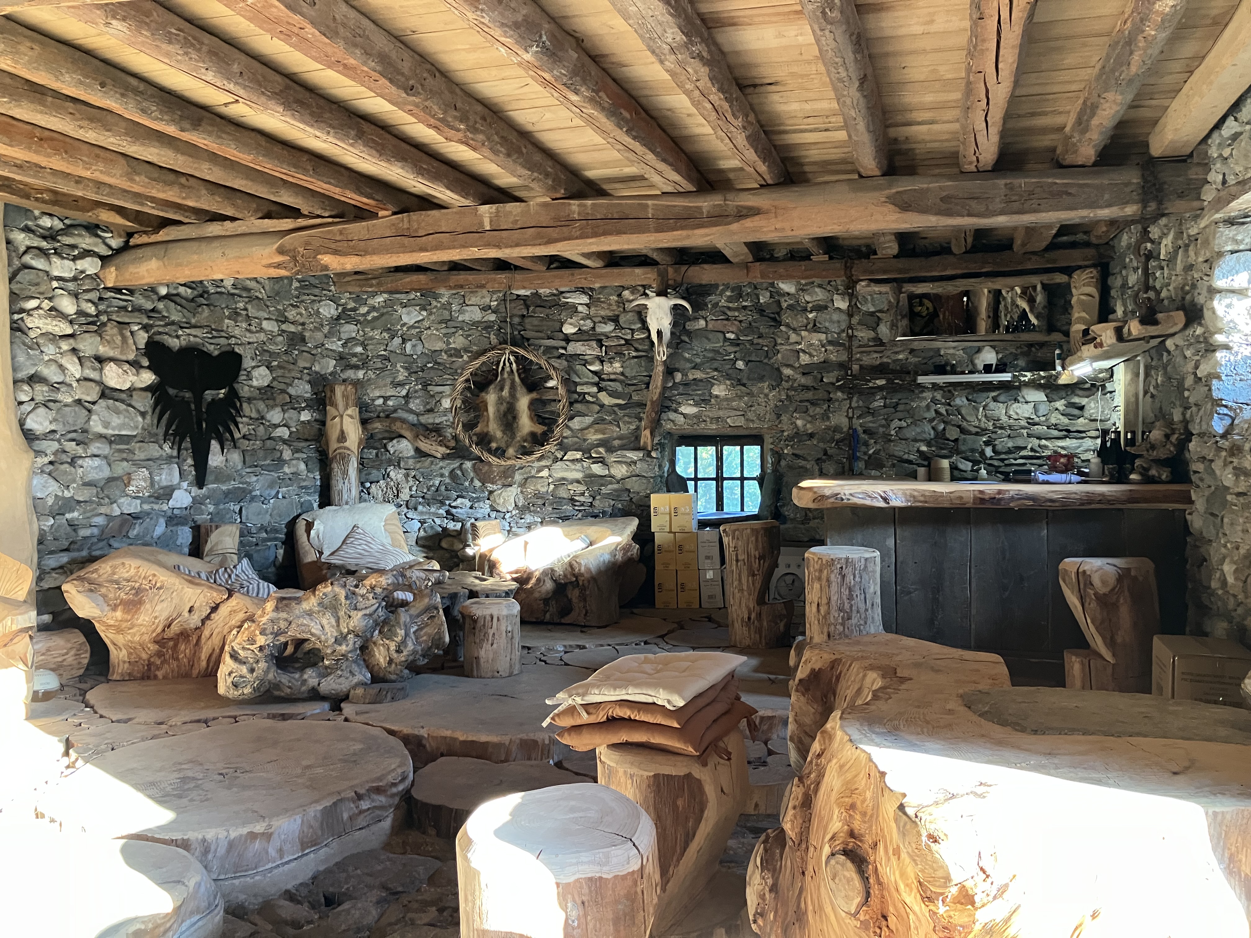 L'intérieur de La Taverne : espace couvert ouvert sur la scène, tables en bois et en ardoise, ambiance de partage.