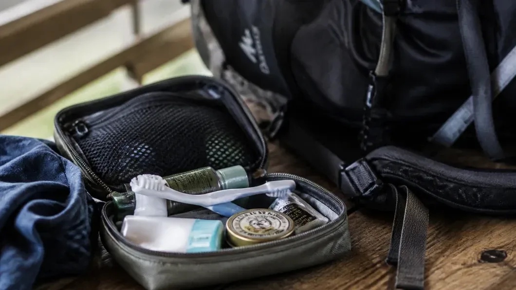 Trousse d'hygiène ouverte à côté d'un sac de randonnée